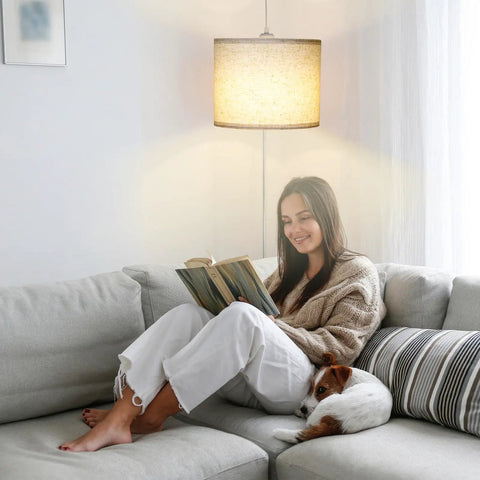 Slick Adjustable Plug In Pendant Light With Authentic Beige Linen Shade illuminates cozy reading nook with woman and dog on sofa.
