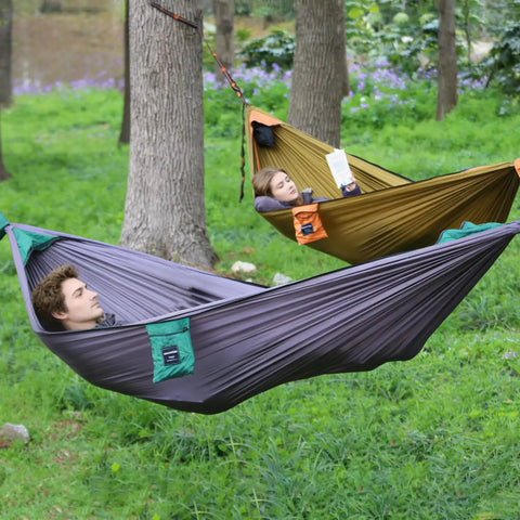 People relaxing in Ultralight Camping Hammock With Integrated Mosquito Net And Tree Straps Quick Setup Backpacking Hammock in a forest