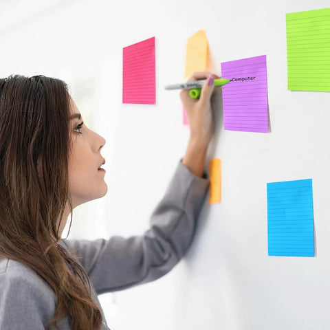 Woman using Nine Pack 4x6 Inch Lined Sticky Notes With Lines In Nine Bright Colors Large Ruled Self Adhesive Note Pads on wall