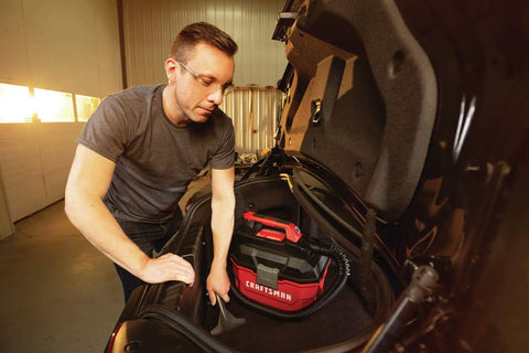 Person using Cordless Shop Vac Vacuum Cleaner Wet And Dry 2 Gallon Tank With 7 Foot Hose Bare Tool Only in car trunk