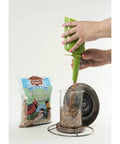 Filling feeder with Real Deal Backyard Wild Bird Food Mix Featuring Natural Cherry Flavor And Hearty Sunflower for easy dispensing.