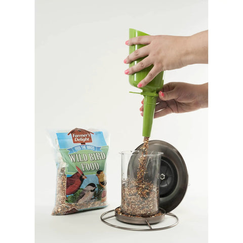 Filling feeder with Real Deal Backyard Wild Bird Food Mix Featuring Natural Cherry Flavor And Hearty Sunflower for easy dispensing.