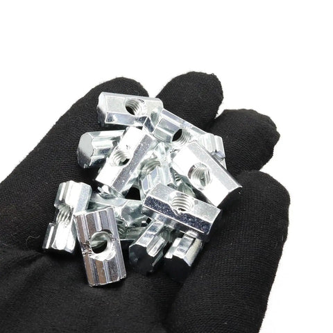 100 Piece M6 T Slot Slide Nuts For Aluminum Extrusion Framing Pro Grade Galvanized Steel Fasteners in hand, showcasing detail and size.