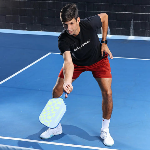 Person playing pickleball with CP7 8 Oz Pickleball Paddle Lightweight Carbon Fiber With Textured Surface For Ultra Spin, Power And Control