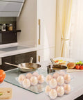 36 Pack Clear Plastic Egg Cartons with Six Egg Capacity Eco Friendly Disposable Egg Holders on kitchen counter next to dishes.