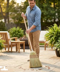 Man using Handmade Corn Broom With Wood Handle For Indoor And Outdoor Use Heavy Duty Garage And Patio Sweep 56 Inch Long 9 Inch