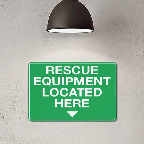 Green sign reading 'Rescue Equipment Located Here' under lamp; Equipment Storage Safety Caution Sign 8x12 Aluminum Plaque With Reflective Sheeting Rust Free Water Repellent Simple Mount For Factory Warehouse Emergency Gear Storage Area See It Clearly No Sweat.