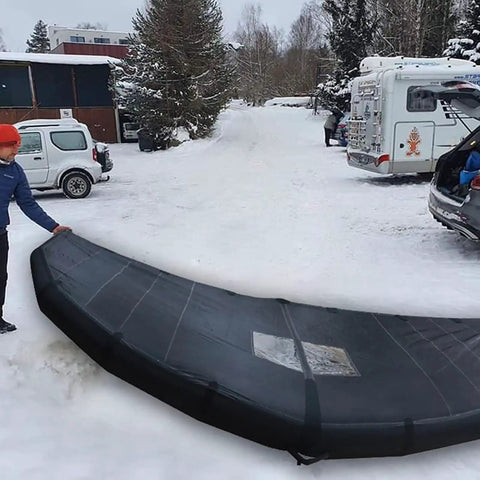 Person with Handheld Inflatable Surf Wing For Windsurfing And Kitesurfing in snowy parking area, Durable Nylon Build