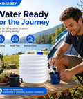 Man using Collapsible Water Container With Spigot For Camping And Road Trips on picnic table by tent