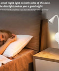 Total Game Changer Led Wall Mount Reading Lamp With Touch Panel And Five Dimmer Settings For Peak Cozy Vibes Includes Usb Charge Port Smart Night Timer And Flexible Gooseneck Design In Clean White next to a sleeping person.