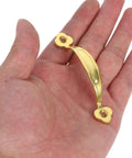 Hand holding a vintage zinc alloy cabinet pull handle with antique gold finish for wardrobe and drawer, part of a 10-pack.