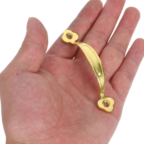 Hand holding a vintage zinc alloy cabinet pull handle with antique gold finish for wardrobe and drawer, part of a 10-pack.
