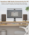 Desktop setup with 60W Powered Bookshelf Speakers For Vinyl Turntable And Computer, brown finish, beside monitor on wooden desk.