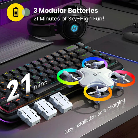 Beginners Drone For Kids With 3 Batteries And Easy Flight Modes HS180 atop keyboard, 3 modular batteries, colorful LED lights.