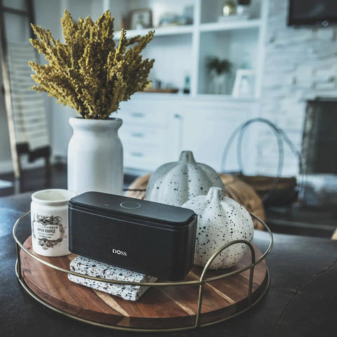 12W Bluetooth Speaker With Rich Bass And Crystal Clear Sound, IPX5 Waterproof on a decorative tray with vases in a modern living room