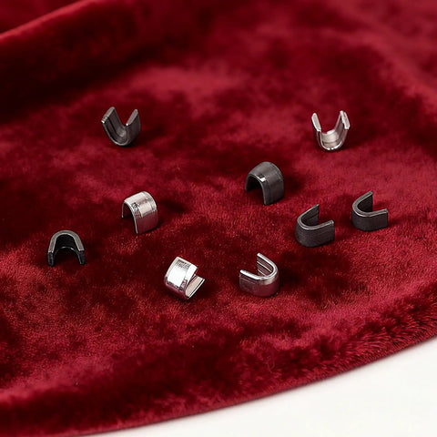 Metal slider retainers on red fabric for Zipper Repair Kit With Metal Insertion Pins, Slider Retainers, And Top And Bottom Stops, 80 Piece Set