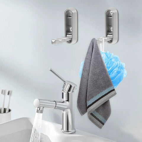 No Sweat Foldable Invisible Wall Hooks Zinc Alloy Storage Hangers 4 Pack mounted on bathroom wall holding towel and loofah.