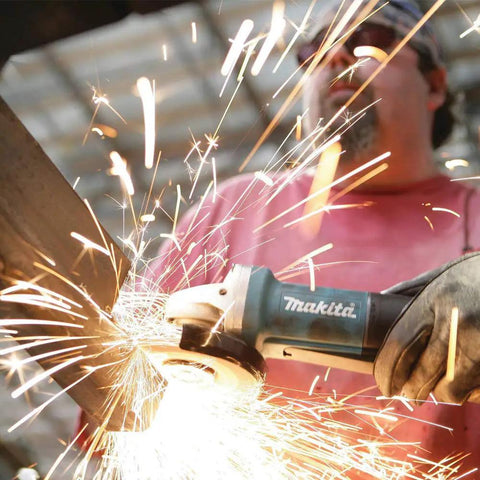 Worker using Paddle Switch 4-1/2 Inch Angle Grinder With 7.5 Amp Power on metal, sparks flying