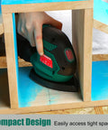 Person using Compact Electric Detail Sander With 14,000 OPM inside a small wooden structure, showcasing easy access to tight spaces.