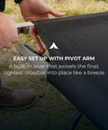 Person setting up heavy duty camping cot for adults with pivot arm for easy assembly outdoors.