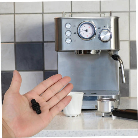 Person holding Barista Grade Heatproof Rubber Steam Wand Sleeve For Espresso Machines in front of coffee maker