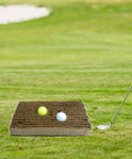 Golf Bunker Practice Mat With Realistic Sand Pit Feel Outdoor Training Accessory For Adults Includes Bunker Brush next to two golf balls