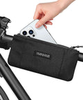 Hand placing phone in Water Resistant Top Tube Bike Bag For Phone And Cards Grab And Go Compact Frame Pouch For Road And Mountain Bikes Perfect For Short Rides And Quick Access Storage On The Fly on bike.