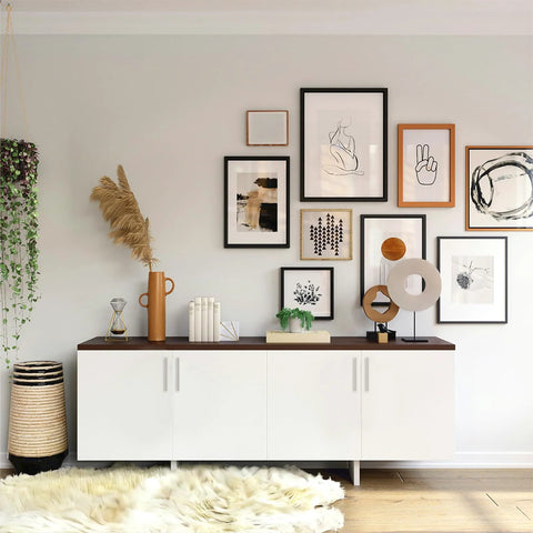 Modern living room with white cabinet, framed art, plants, and decor pieces on a shelf