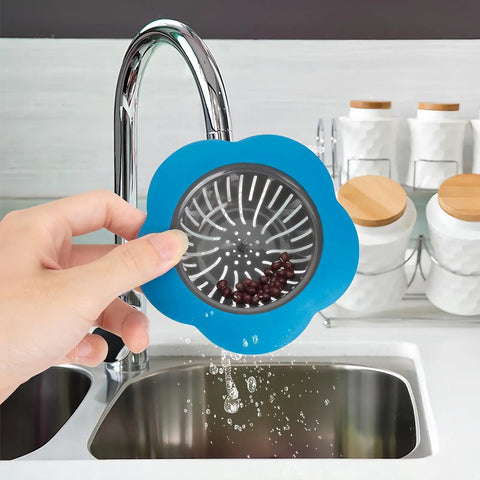 Holding a blue Colorful Silicone Kitchen Sink Strainers Set Of 4 With Large 4.5 Inch Wide Rim above the sink