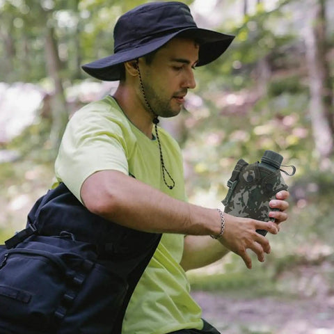 Person holding Camouflage Insulated Water Bottle 1L With Strap And Thermal Lining Rugged Aluminum Hydration Flask hiking outdoors