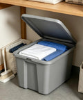 Straight Up Tough As Nails Heavy Duty Plastic Storage Bin With Secure Snap On Lid For Real Garage Setup Or Home Decluttering Projects Gray 18 Gallon Capacity filled with folded clothes.