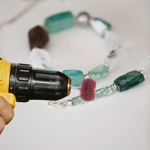 Kick Your Projects Into High Gear With This Epic 40-Piece Buffing Wheel Set For Drills Featuring Heavy Duty Fiber And Alloy Wheels That Polish Wood Or Plastic Fast Without The Frustration For Serious Pro Vibes. Image showing a drill with a buffing wheel polishing a colorful beaded necklace.