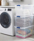 Hella Tough 66 Quart Clear Plastic Storage Bins With Secure Twist Latches And Smart Stack Design, stacked with folded towels.
