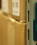 Grab And Go Humidity And Temperature USB Data Logger With 16,000 Readings Memory, mounted on a metal shelf in a storage room.