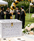 Slick White Silhouette Wedding Card Box With Lock And Slot on table, surrounded by roses and graduates in background.