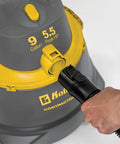 Hand connecting hose to Contractor Wet Dry Vacuum Cleaner For Jobsites And Shops With 9.0 Gallon Tank 1200 Watt Power