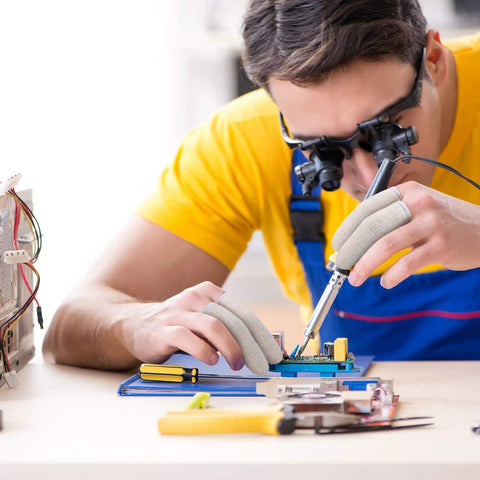 Technician wearing Moisture Wicking Cotton Finger Cots And Toe Sleeves Set For Glove Comfort while working on electronics.