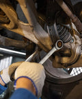 Mechanic using 18mm Ratchet Wrench With A Beefy 12 Point Box End And 72 Tooth Ratcheting on car suspension, close-up view