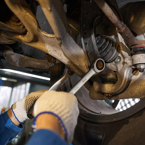 Mechanic using 18mm Ratchet Wrench With A Beefy 12 Point Box End And 72 Tooth Ratcheting on car suspension, close-up view