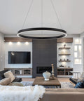 Modern LED Ring Chandelier With Uplight And Downlight, Black Dimmable Circular Pendant Light illuminating a contemporary living room.