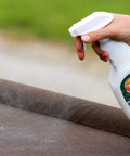 Hand spraying Outdoor Fabric Guard Restores Water Repellency To Factory New Levels onto brown fabric surface