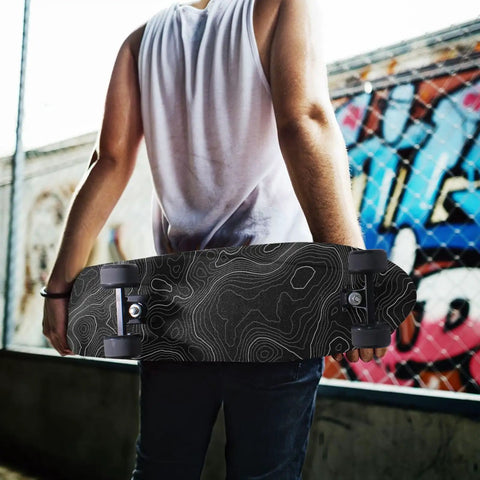 Person holding skateboard with Contour Map Grip Tape For Skateboards 33 By 9 Inches Black With White Contour Lines, urban background.