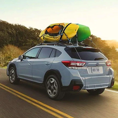 Car with kayaks secured by Beefy 16 Foot Tie Down Straps With Rubber Padded Cam Lock Buckle, 1 Inch Wide, 600 Lb Working Load on roof rack