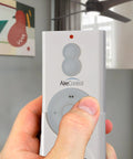 Person holding RC210 Hand Held 32 Bit AireControl Ceiling Fan Remote System for fan control and light dimming.