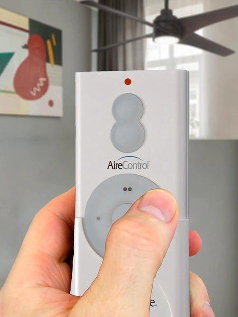 Person holding RC210 Hand Held 32 Bit AireControl Ceiling Fan Remote System for fan control and light dimming.