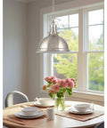 14 Inch Modern Industrial Pendant Light With Dome Shade In Brushed Nickel Finish hanging over dining table, pink flowers vase.