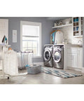 Modern laundry room with stainless steel washer and dryer, ironing board, and light gray cabinets.