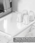 Silicone Coffee Mat 12 By 19 Inches with cups and espresso machine on marble counter, white, waterproof raised edge bar mat