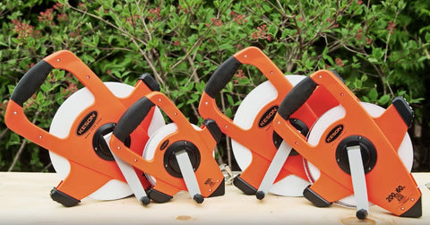 Collection of NRS18M330 Nylon Reinforced Tape Measures with Beast Speed Rewind on a wooden surface, orange cases visible