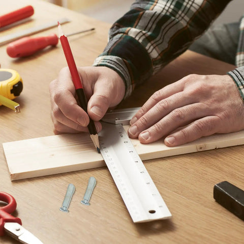 Person measuring wood with ruler and pencil next to screws from Eight Piece Hacksaw Bolt And Wing Nut Set For DIY Repairs Tough Pro Grade Hardware Kit